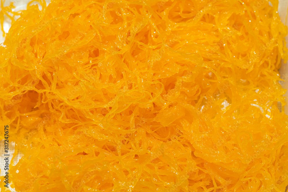 Foi thong or Shredded egg yolk tart or golden threads made from egg yolks of duck eggs. Simmer in boiling water and granulated sugar. Foi thong or Shredded egg yolk tart or golden threads made from egg yolks of duck eggs. Simmer in boiling water and granulated sugar.