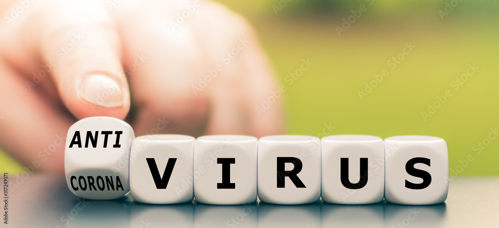 Hand turns a dice and changes the expression "Corona Virus" to "Anti Virus". - obrazy, fototapety, plakaty 