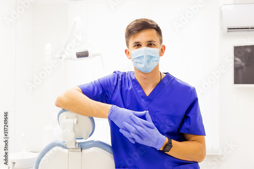 Phisician male doctor in blue uniform in clinics office provides healthcare sercises