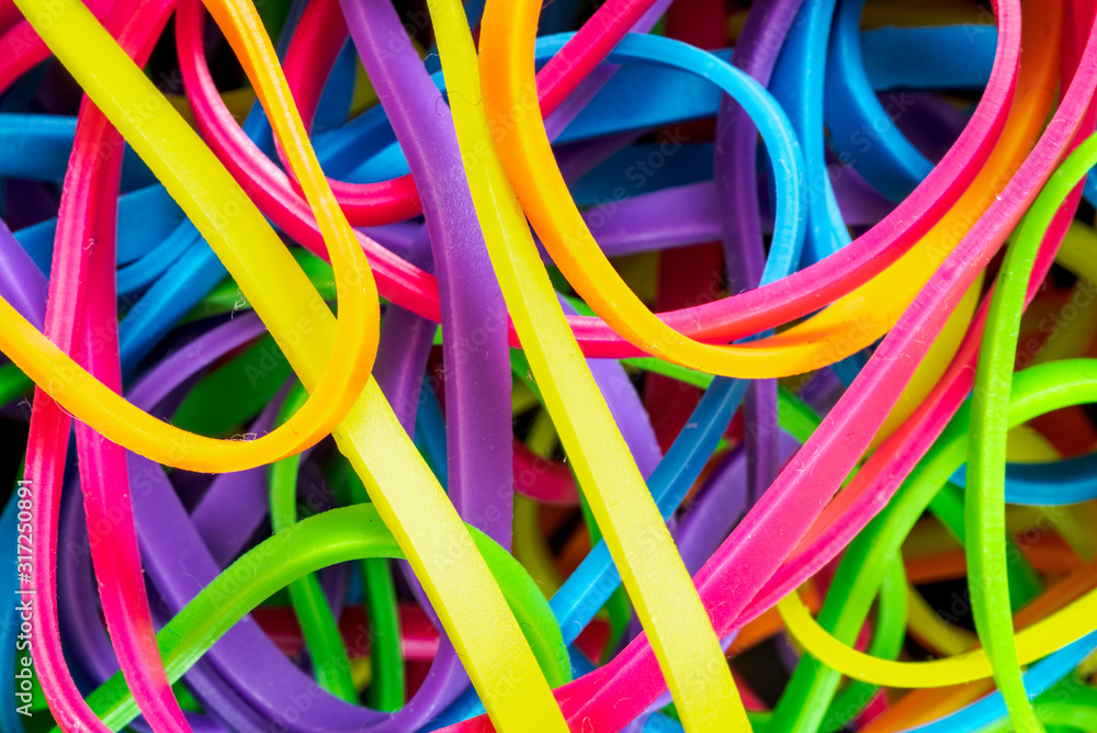 pile of colorful small rubber bands isolated on a black back ground