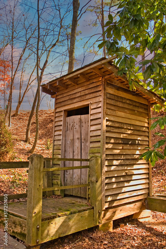 An old outhouse of wood behind a farm house in the country