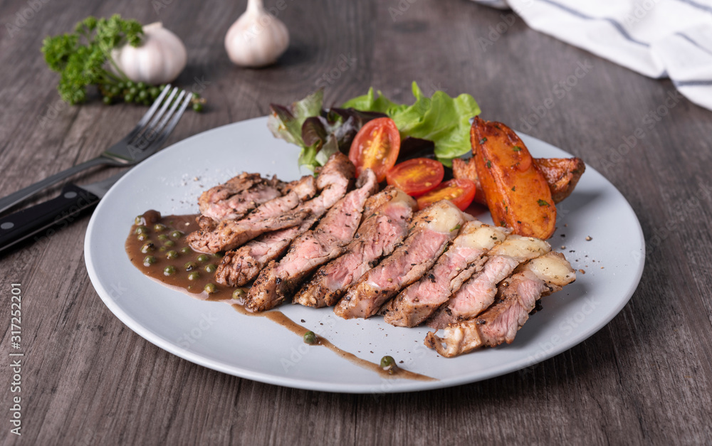 beef steak and vegetable salad and potato chips in white plate on table restaurant. top view.