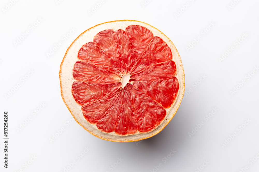 Slice of red dry grapefruit on gray background with shadow Slice of red dry grapefruit on gray background with shadow