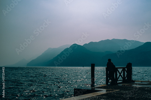 A person looks at a lake with a mountain