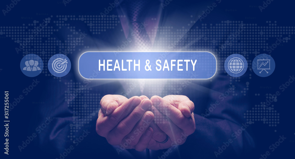 Businessmans cupped hands holding an Health and Safety business concept on a computerised display.