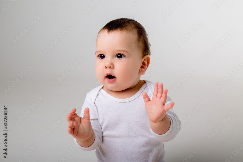 portrait of a baby boy looking at the camera in a white bodysuit on a white background, space for text portrait of a baby boy looking at the camera in a white bodysuit on a white background, space for text
