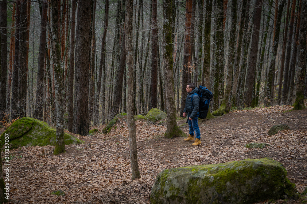Man walking alone in deep autumn forest