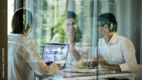 The business group discussing the project, in a room behind the glass