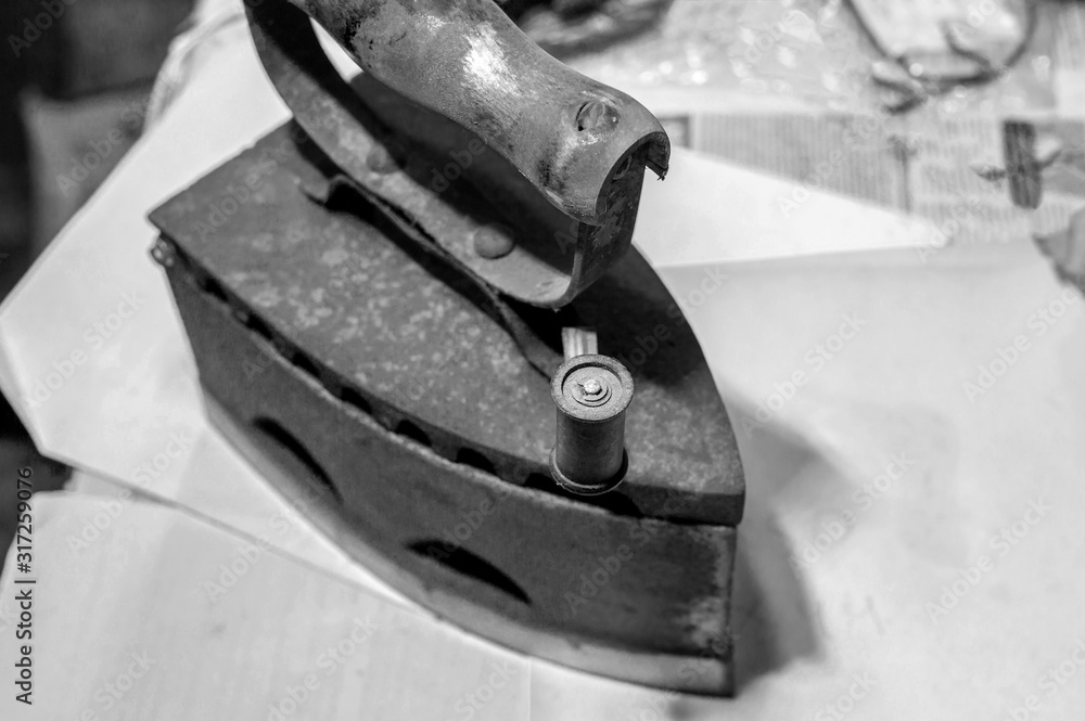 Antique Cast Iron Coal Iron. Workshop for restoration. Black and white tint, selective focus Antique Cast Iron Coal Iron. Workshop for restoration. Black and white tint, selective focus