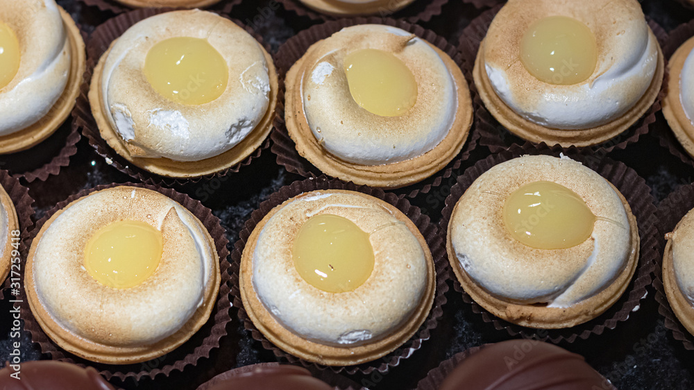 Small meringue tarts with lemon cream on top, top view. Small meringue tarts with lemon cream on top, top view.