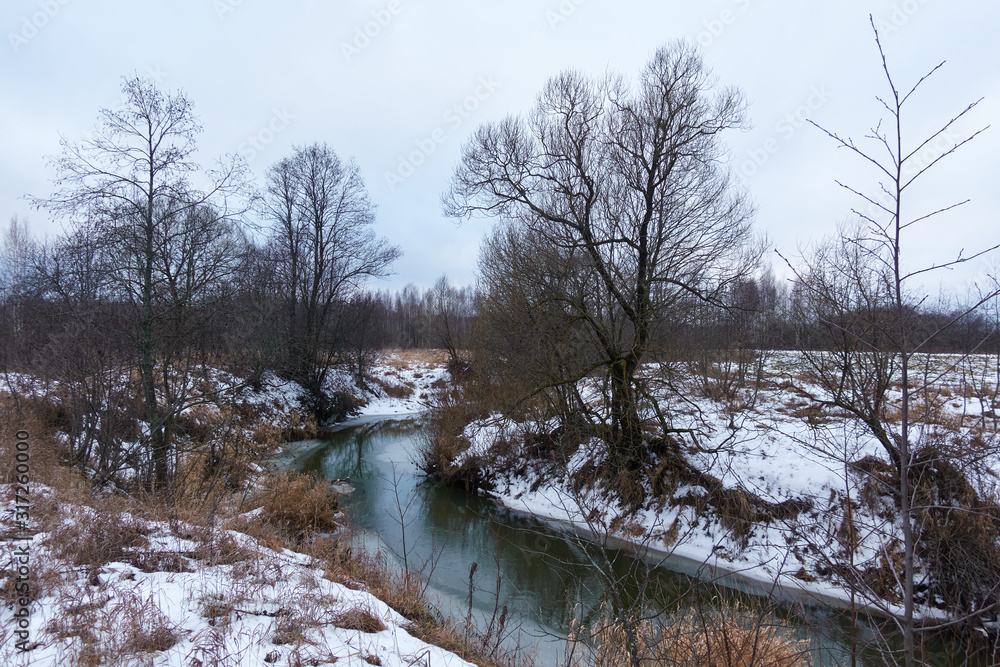 Spring landscape with river, ice and snow on the banks Spring landscape with river, ice and snow on the banks