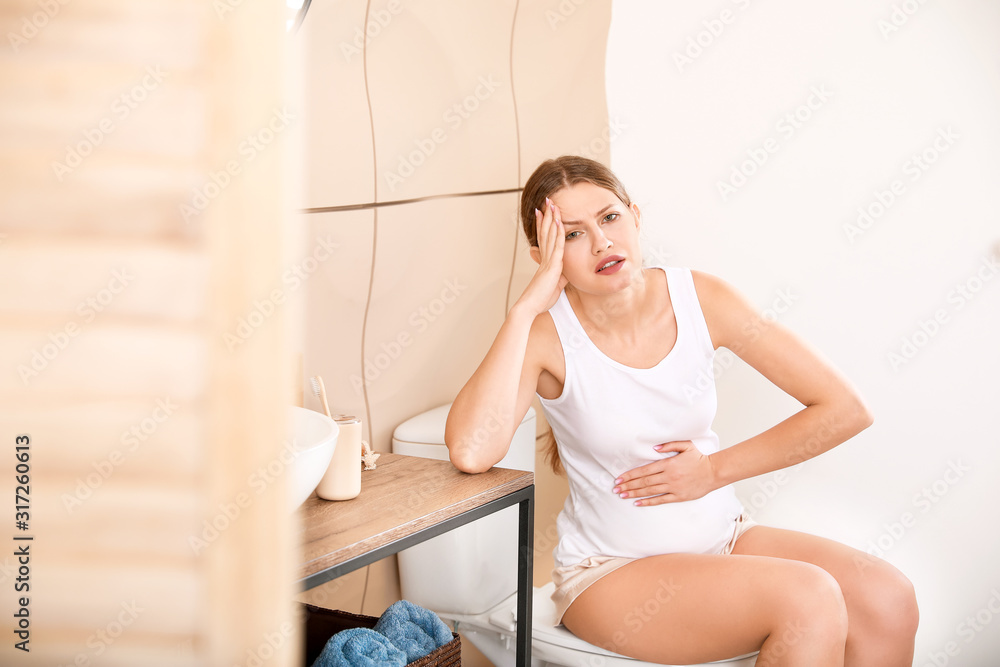 Pregnant woman suffering from toxicosis in bathroom Pregnant woman suffering from toxicosis in bathroom