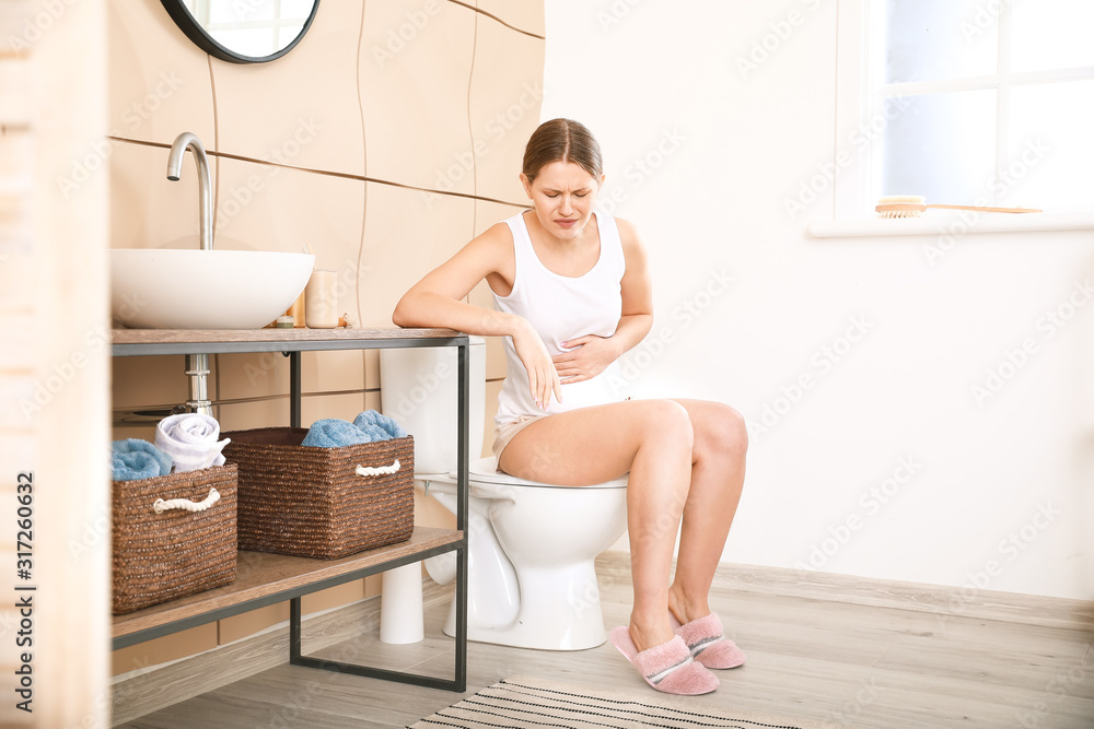 Pregnant woman suffering from toxicosis in bathroom Pregnant woman suffering from toxicosis in bathroom
