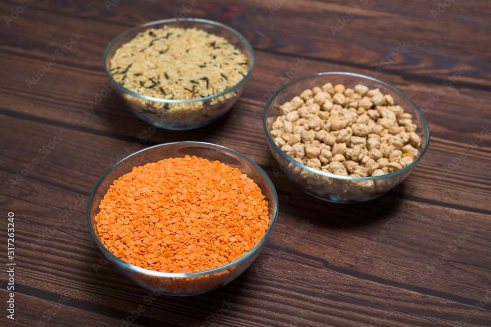 chickpeas, basmati rice and red lentils in a bowl. organic healthy cereals. on a wooden background. natural vegetarian vegetable protein . the view from the top. close-up of grain chickpeas, basmati rice and red lentils in a bowl. organic healthy cereals. on a wooden background. natural vegetarian vegetable protein . the view from the top. close-up of grain