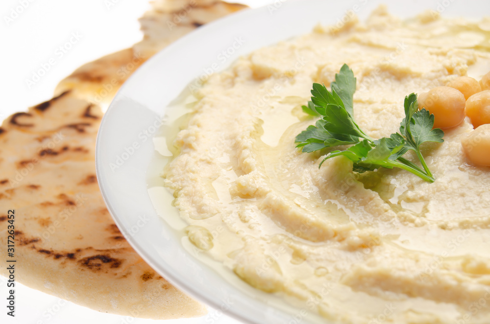 Closeup view at Hummus topped with beans olive oil and green coriander leaves with pita bread Closeup view at Hummus topped with beans olive oil and green coriander leaves with pita bread
