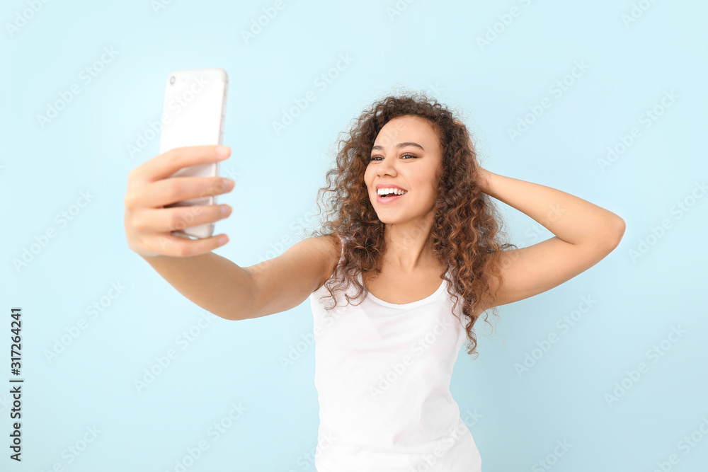 Beautiful young woman taking selfie on color background Beautiful young woman taking selfie on color background