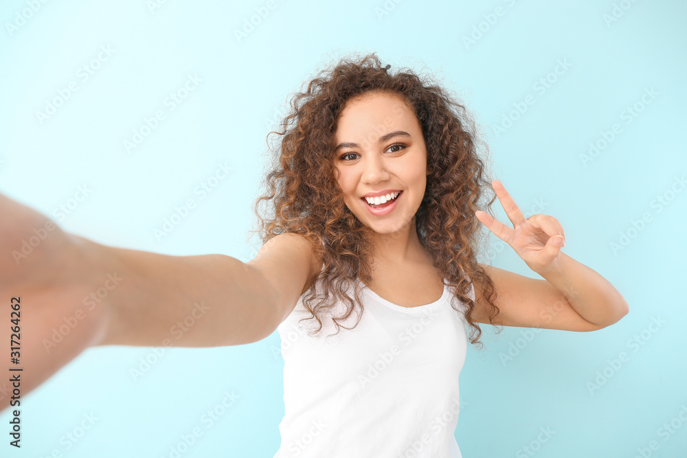 Beautiful young woman taking selfie on color background Beautiful young woman taking selfie on color background