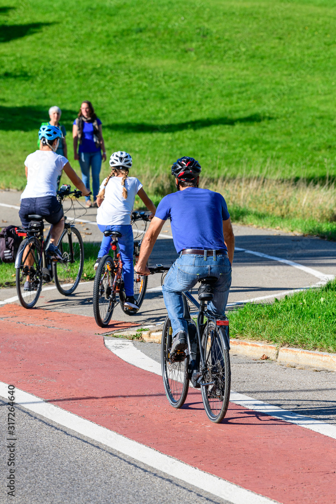Fototapeta premium Radfahrer befahren einen Übergang von der Straße auf einen kombinierten Rad- und Fußweg