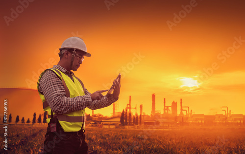 Close-up engineers working in building sites that have tablets, Concept of new plan, white helmet and red radio, Engineering and petrochemical plants - Imagen, PPE conditions in oil and gas refineries