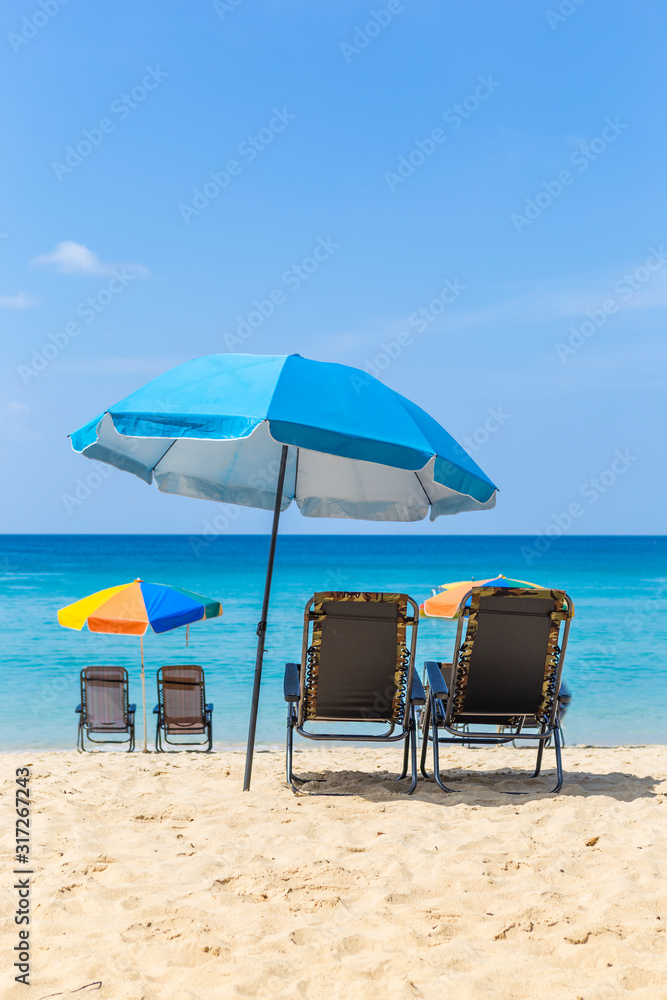 Relaxing on the beautiful beach, summer outdoor day light, holiday and vacation destination, beach chair with colorful umbrella over blue sea background