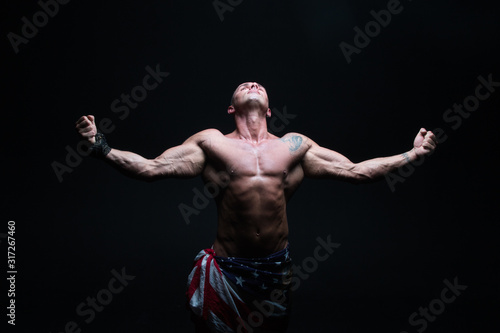 Athletic male bodybuilder on a dark background. A man with a beautiful body.athlete, exercise, health, power, strength, man,