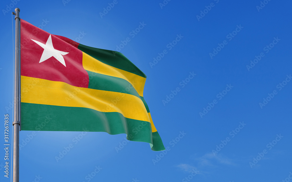 Togo flag waving in the wind against deep blue sky. National theme,  international concept. Copy space for text. Stock Photo