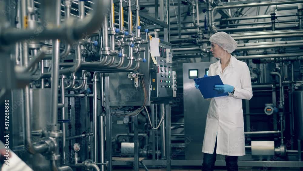 Factory facility with electronic equipment being operated by a female worker Factory facility with electronic equipment being operated by a female worker