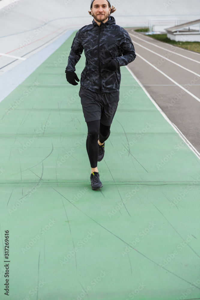 Confident young fit sportsman running on the race track Confident young fit sportsman running on the race track