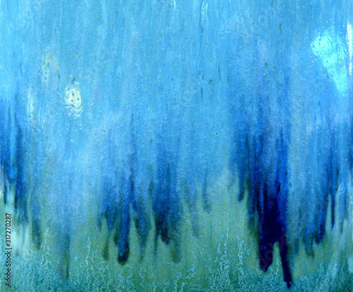 The surface of the ceramic jug. Covered with colored glaze. Rich shades of blue, turquoise color. Blurred image