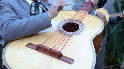 Mariachi musician playing the guitarron. Guitarron detail