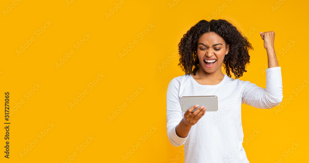 Gambling afro girl playing video game on smartphone, celebrating victory Gambling afro girl playing video game on smartphone, celebrating victory