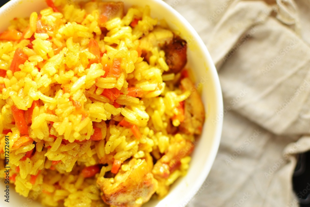 Basmati rice with chicken and carrots. Spicy rice with turmeric, in a white plate, bowl. View from above. Top view. Basmati rice with chicken and carrots. Spicy rice with turmeric, in a white plate, bowl. View from above. Top view.