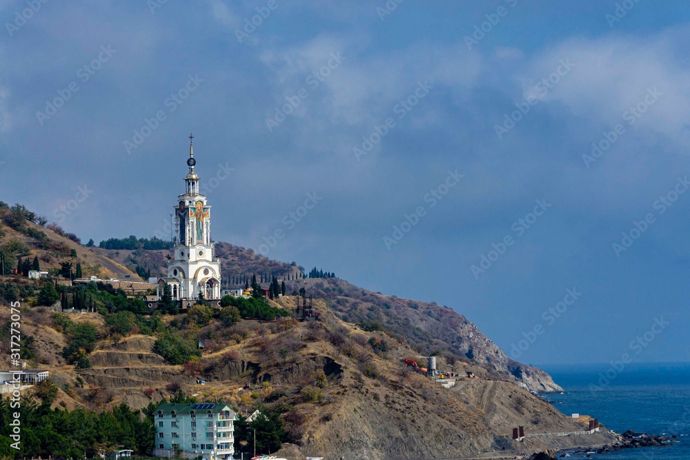 Malorechenskoye, Crimea, Russia - October 01, 2019. Temple of St. Nicholas Mira patron saint of travelers and sailors on seashore and on edge of cliff. Highest temple in Crimea is lighthouse.