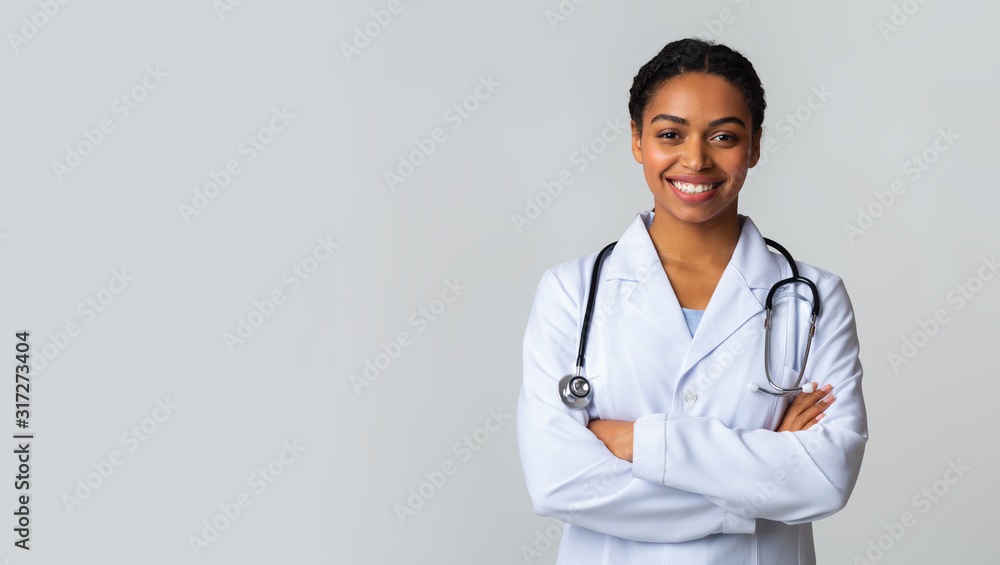 Smiling Black Female Doctor In White Coat Posing With Folded Arms Smiling Black Female Doctor In White Coat Posing With Folded Arms