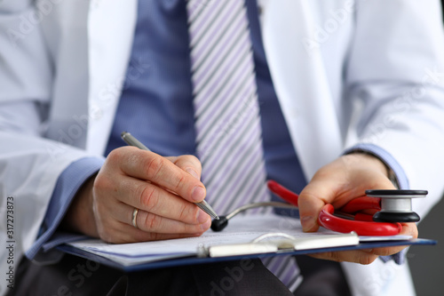 Male medicine doctor hand holding silver pen writing