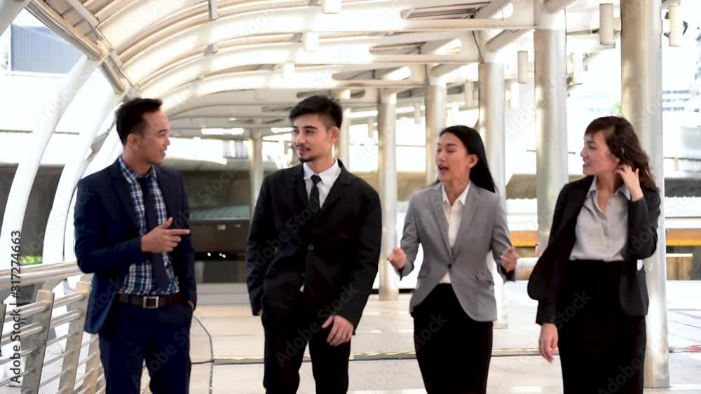 Group of asian business people walking talking together in city. Diversity people partner business meeting brainstorming together businessman trust teamwork. Collaboration Team Meeting concept Group of asian business people walking talking together in city. Diversity people partner business meeting brainstorming together businessman trust teamwork. Collaboration Team Meeting concept