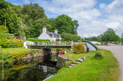 Beauty of Crinan canal - scenic water way with gates and bridges. Summer in Scotland.