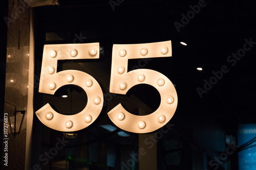 Retro 55 Incandescent Light Bulb SIgn on Urban Street