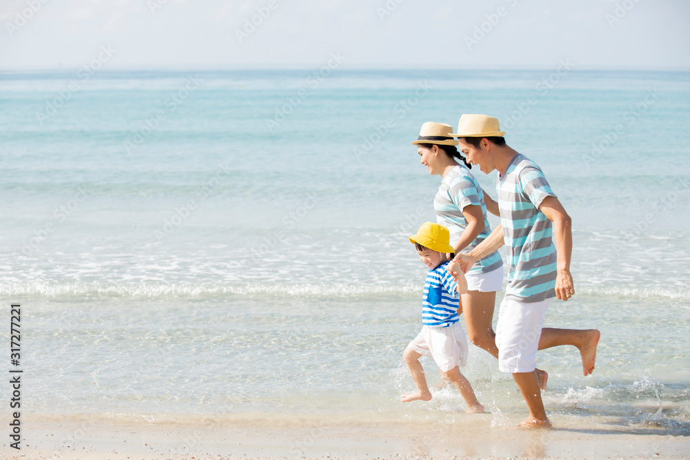 Happy asian family holding hands running on the beach Happy asian family holding hands running on the beach