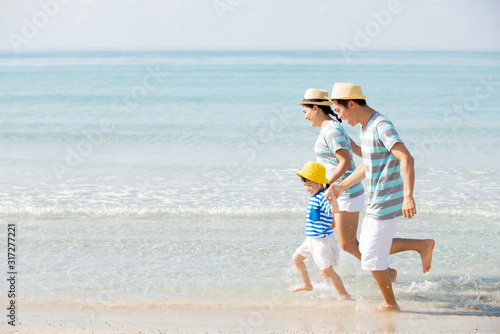Happy asian family  holding hands  running on the beach