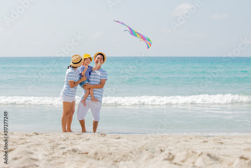 Happy asian family enjoy with kine on the beach