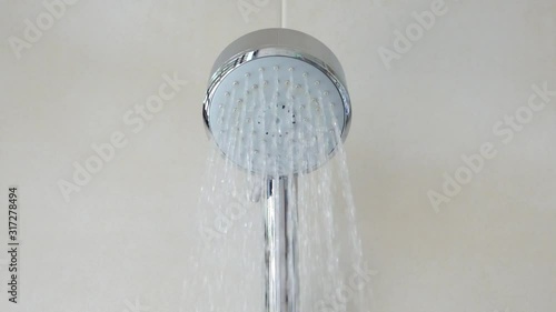 Shower head with limescale turning on. Close up of waterdrops flowing from shower head  in residential bathroom,HD slow motion  video front view.