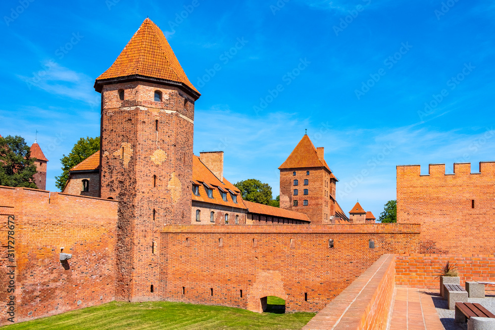 Panoramic view of the medieval Teutonic Order Castle in Malbork, Poland - external defense walls, towers moat and keeps