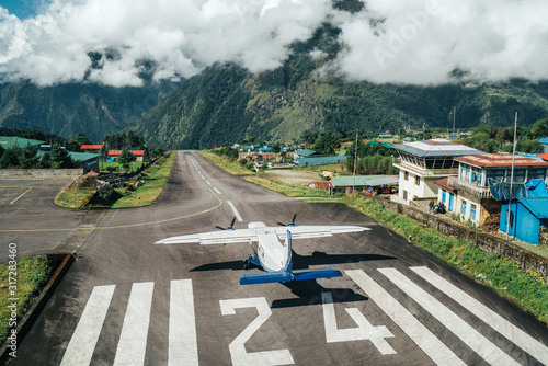 Lukla, NEPAL - October 18, 2019: Twin-engine short-range plane landing at the runway of world's most dangerous airport in Lukla,Nepal. Tenzing–Hillary Airport at altitude 2,845 m