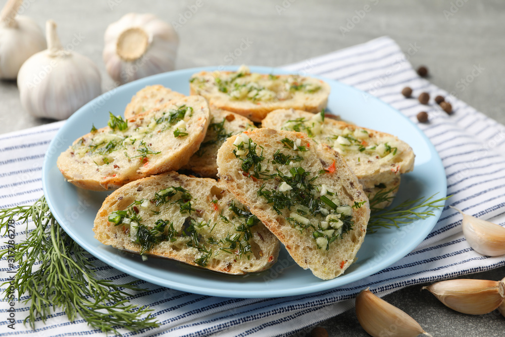 Plate with toasted garlic bread on grey background, close up Plate with toasted garlic bread on grey background, close up