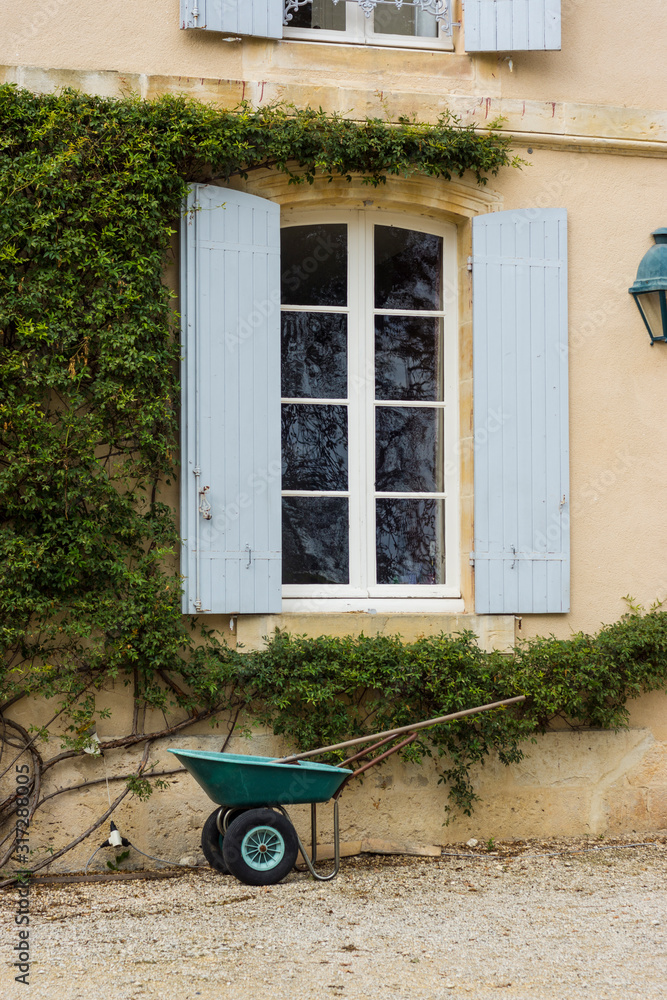 Wheelbarrow in front of french window Wheelbarrow in front of french window