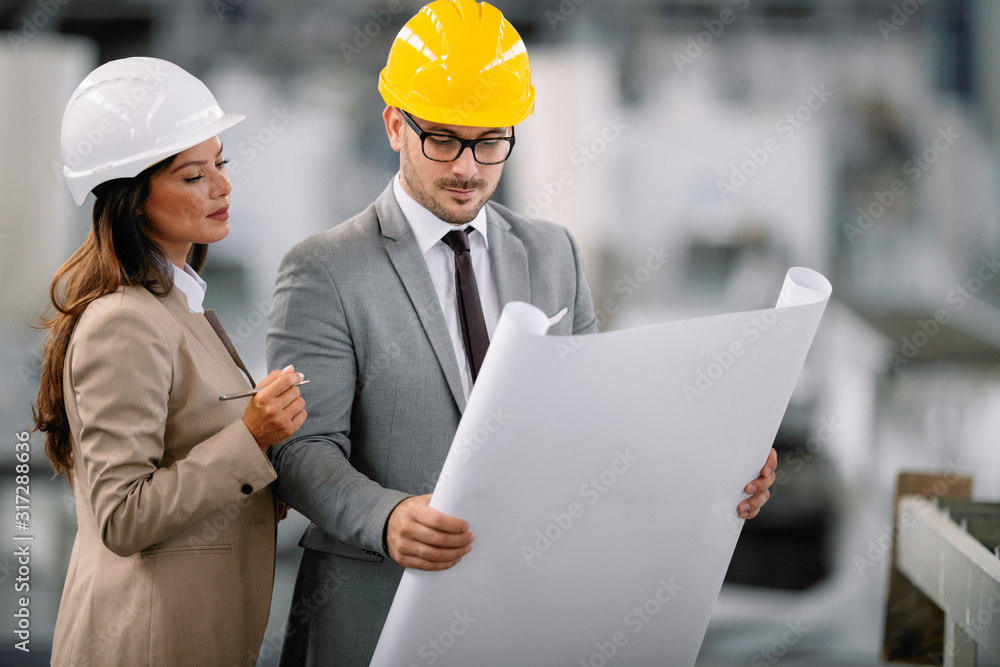 Architects working on construction project. Man and woman discussing work. Architects working on construction project. Man and woman discussing work.