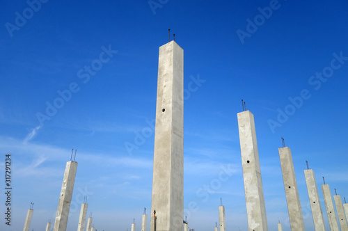 Concrete construction posts against blue sky