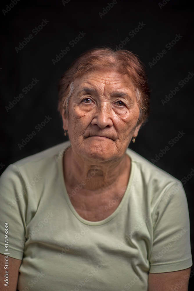 Obraz premium Portrait of an old woman against a dark background. Photographed close-up.