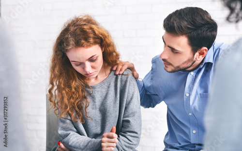 Caring husband comforting his depressed wife on meeting with marriage counsellor